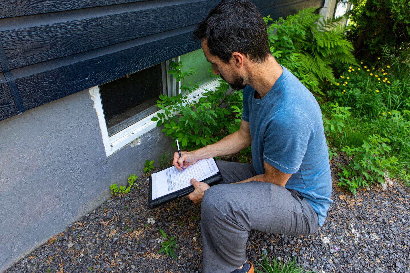 A homeowner inspects their basement with concern, highlighting potential water damage risks like cracks and leaks.